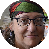white woman with black glasses and head scarf