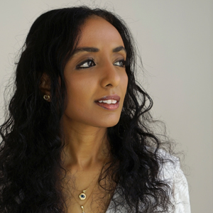 Woman with long curly black hair and necklace