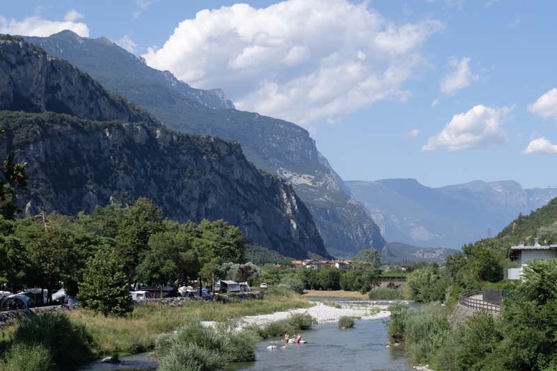 Tall mountains surround a river and lush greenery
