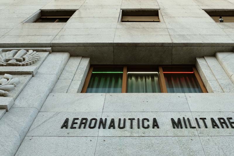 A gray building with a window above a sign in black letters