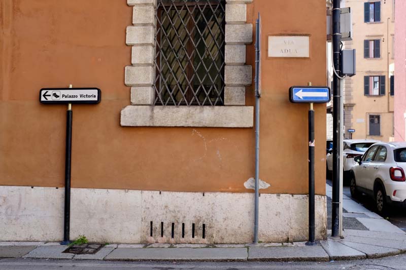 A street corner with signs and cars parked on the street
