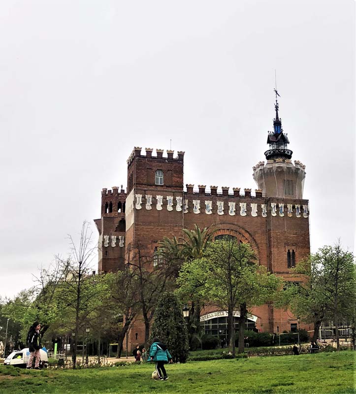 people walking in grass with castle in background