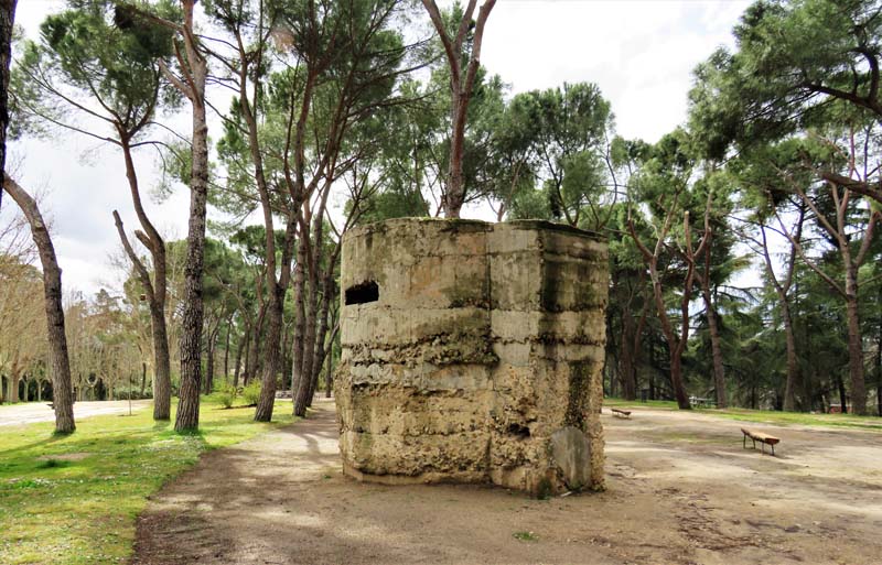 old bunker on sandy parkland, benches in background