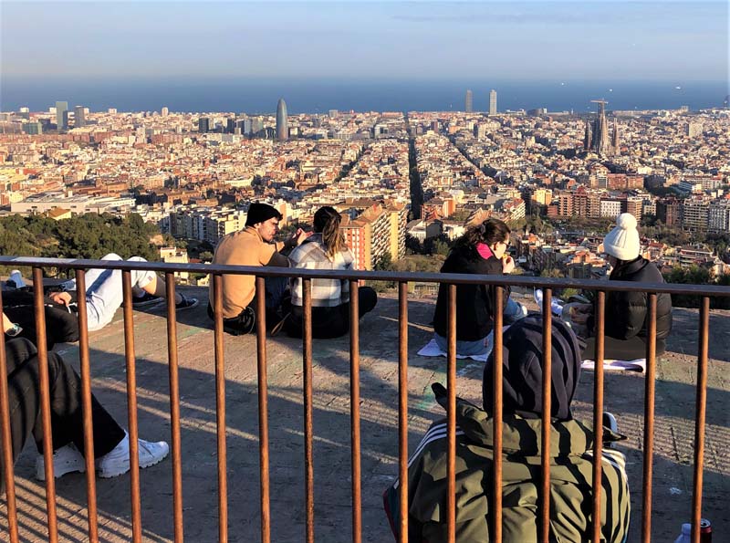 people sit atop building overlooking city