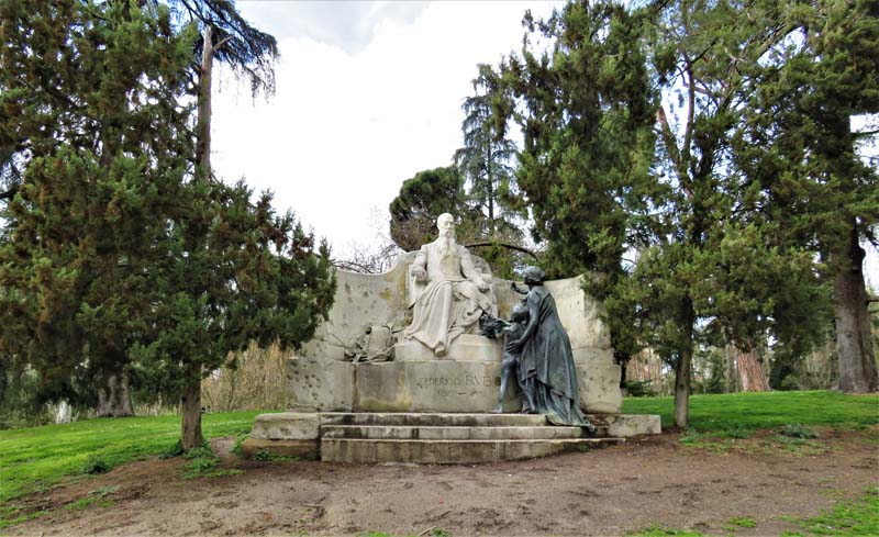 front view of statue, Federico Rubio sits, woman presents her child