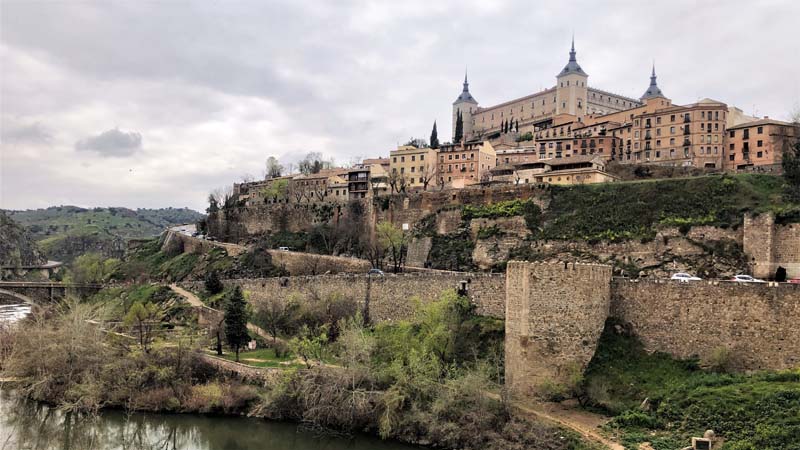 stone walls surround city, river in foreground