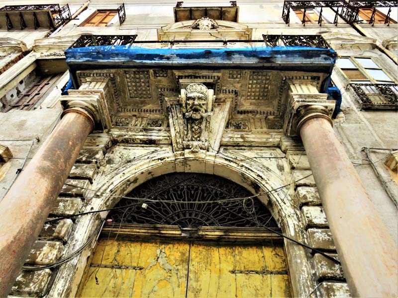 view looking up from arched entrance with face sculpture on keystone