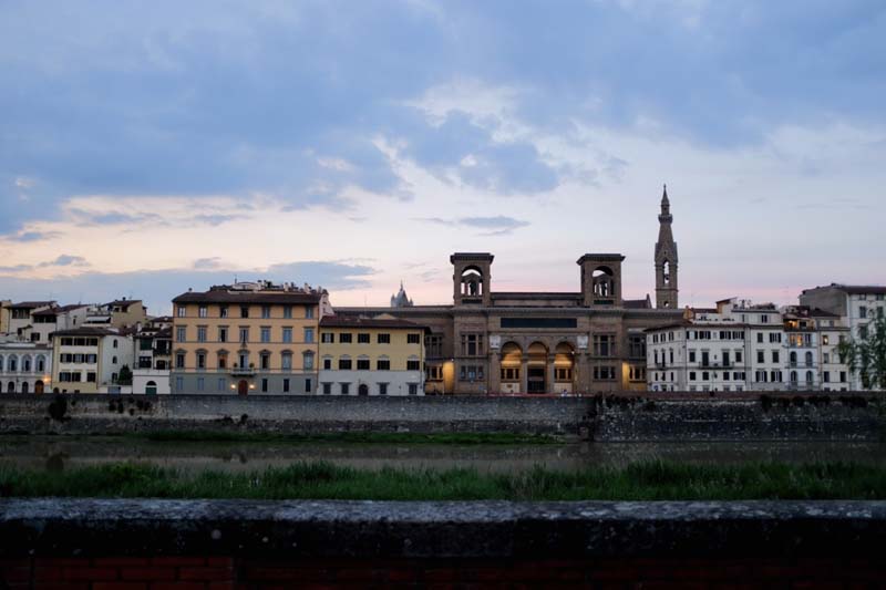 Several mid-rise buildings stand behind a river