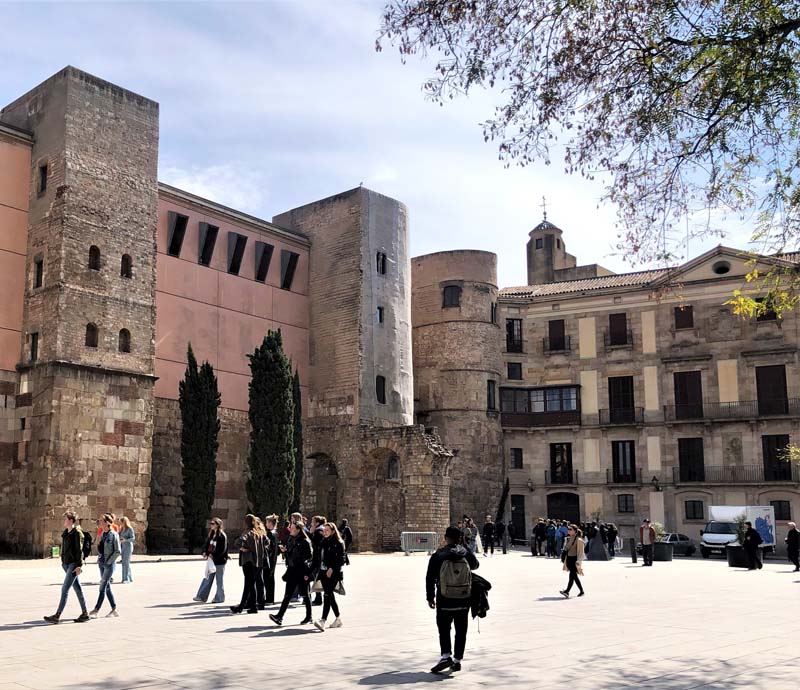 Roman walls and towers, people walking in foreground