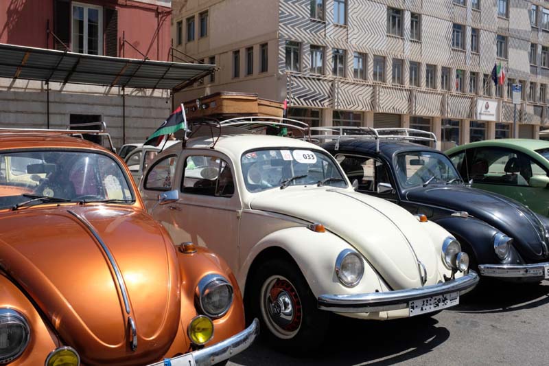 Four vintage cars parked in front of buildings