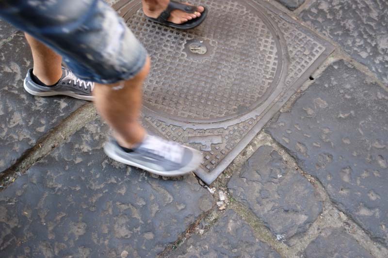 Two people walking on a steel plate on the ground