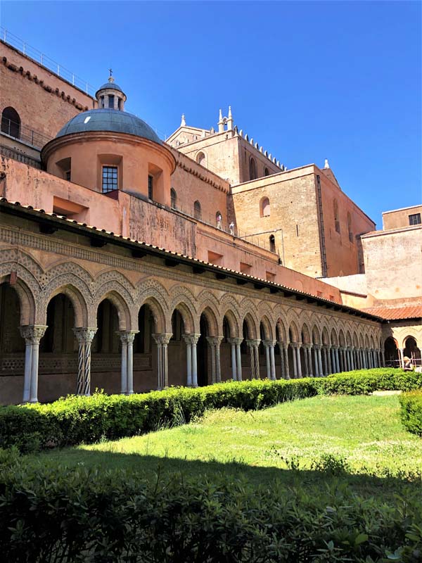 grassy courtyard with arched colonnade