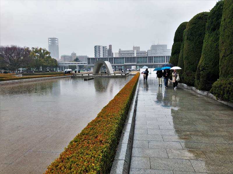 people walk through plaza on rainy day