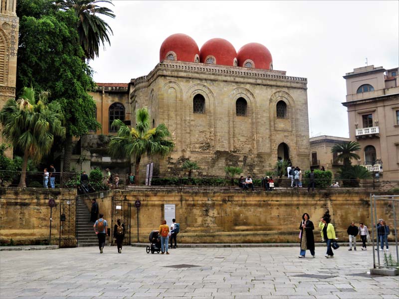 people walk in sunken plaza with building in background