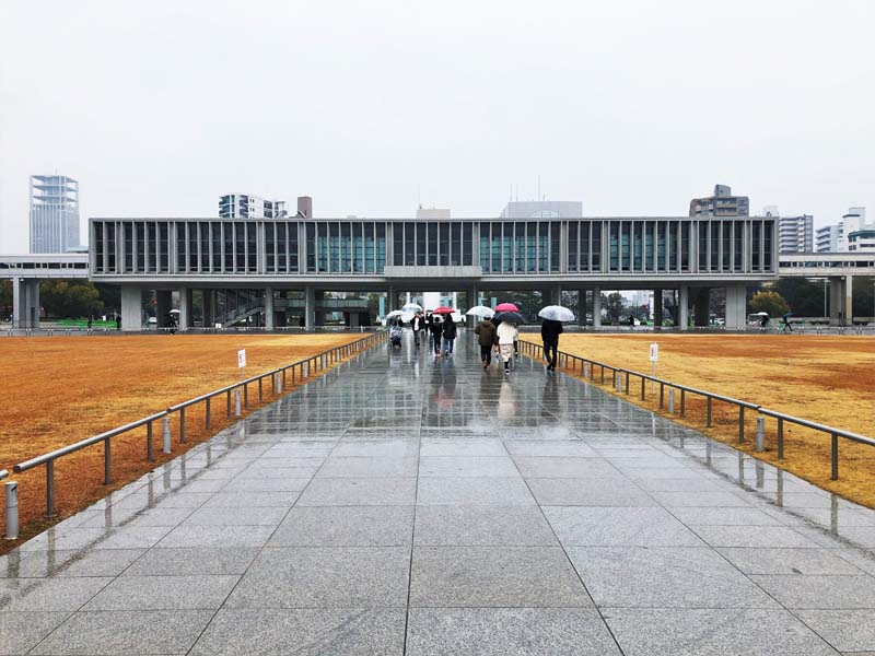 people on walkway with umbrellas