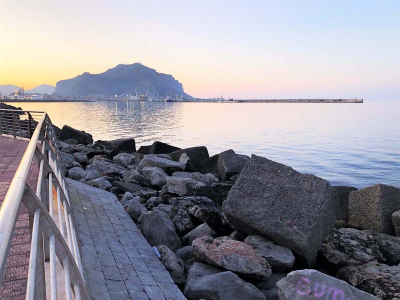 view of sea from boulder-lined walkway