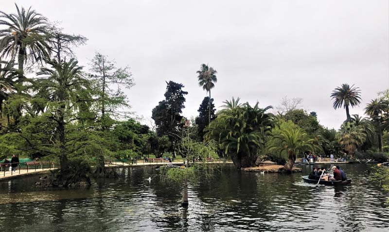 pond with people in boat surrounded by park land