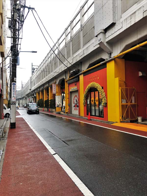 shops under train tracks along a street