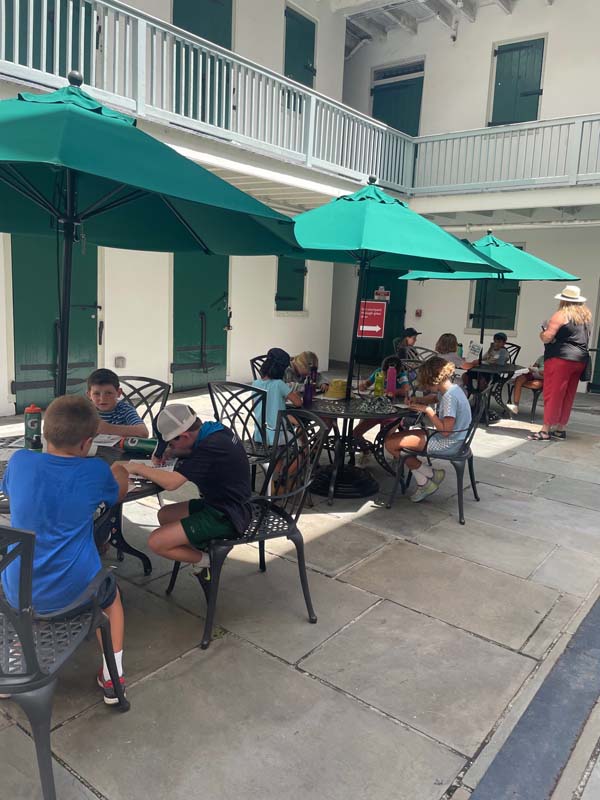 students sketch at tables outside