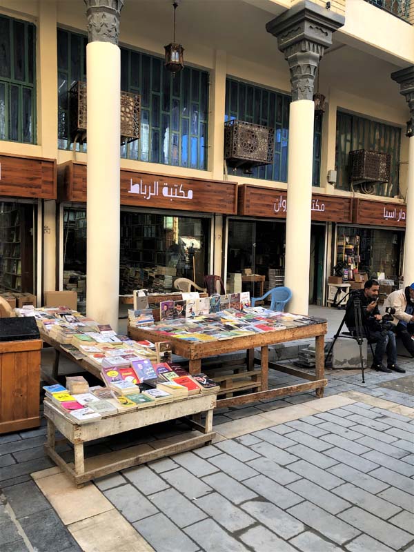 tables display books in front of colonnade storefront