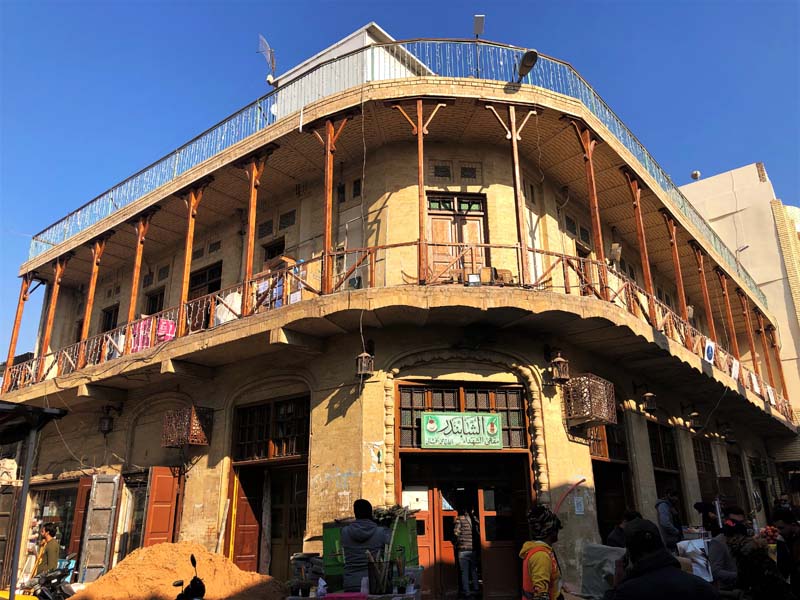 two-story yellow brick building with wraparound balcony