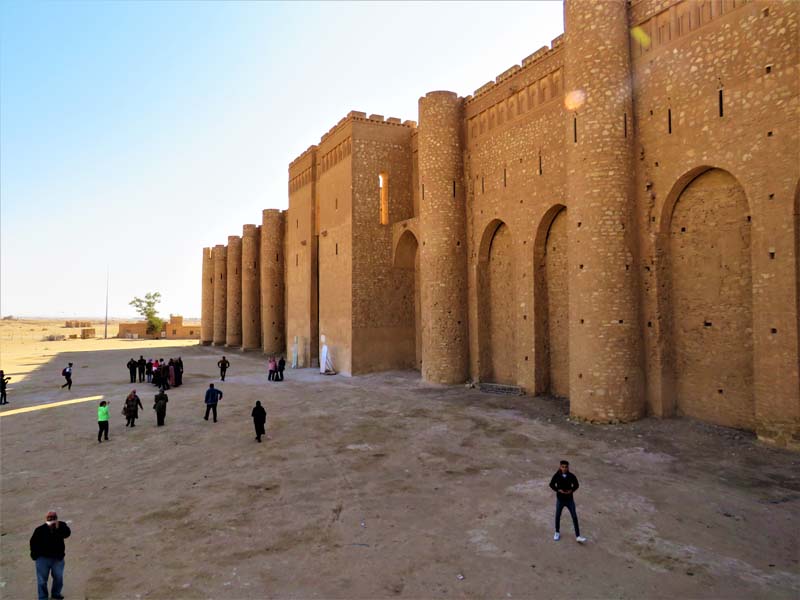 people stand outside fortress walls