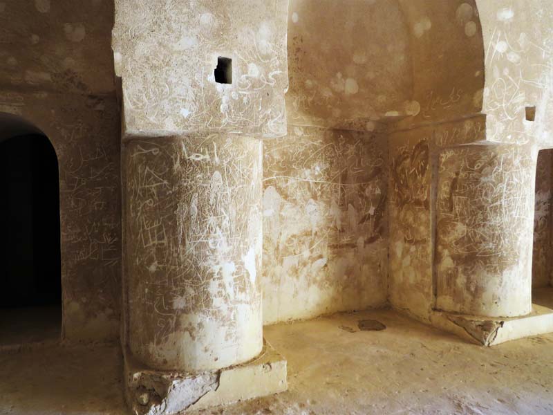 stone walls and columns with etched graffiti