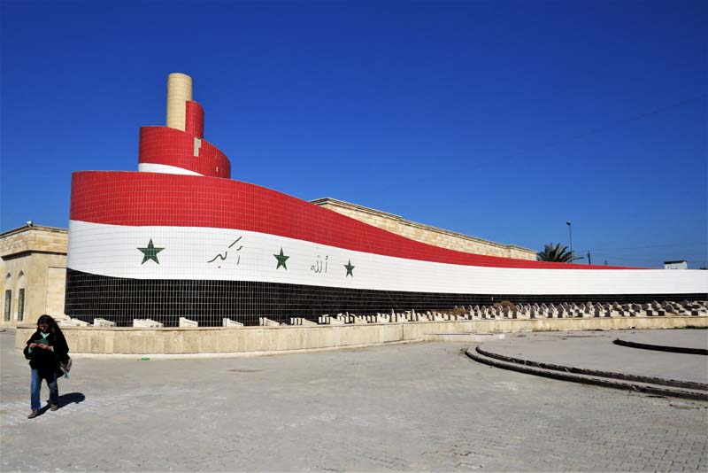 red, white, and black curvilinear memorial with woman in foreground