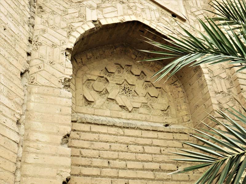 detail of ornamental brickwork, palm fronds in foreground