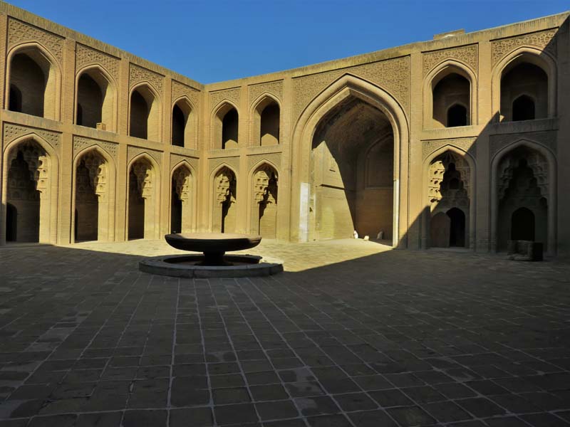 courtyard with fountain and two-story arcade with pointed arched and ornamental brickwork