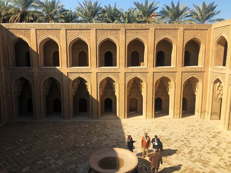 view into courtyard with four men near fountain