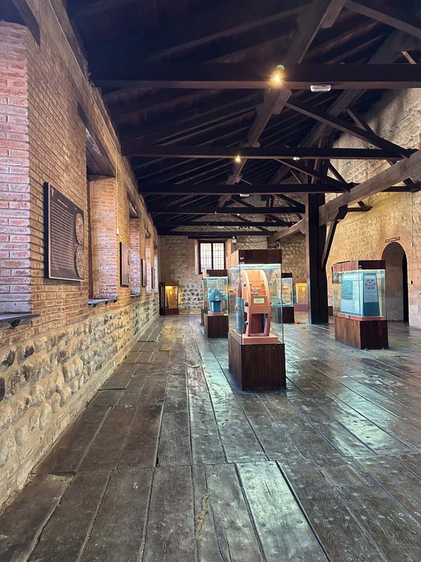 gallery in stone and brick building with wooden truss roof