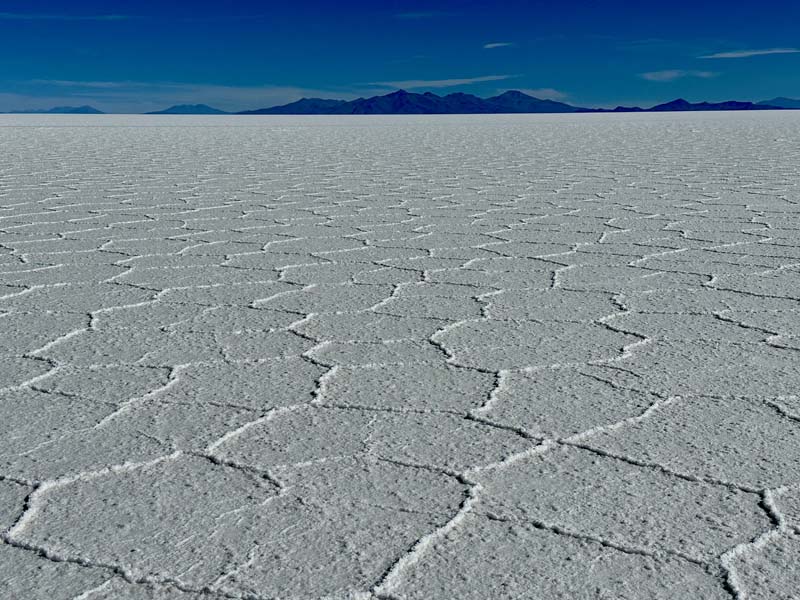 vast expanse of salt flat with mountains in background