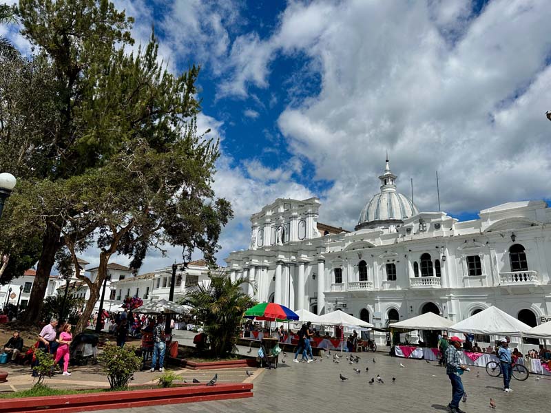 people in plaza with white building in background Figure 2
