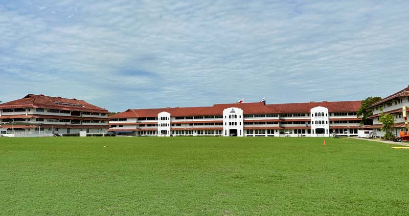 three-story building with field in foreground