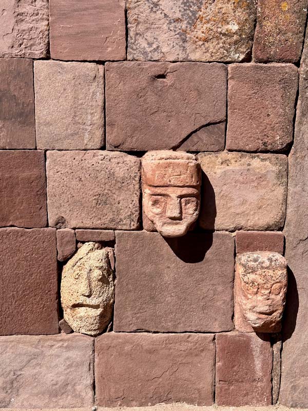 carved faces in stone wall