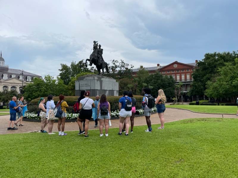 students looking at statue