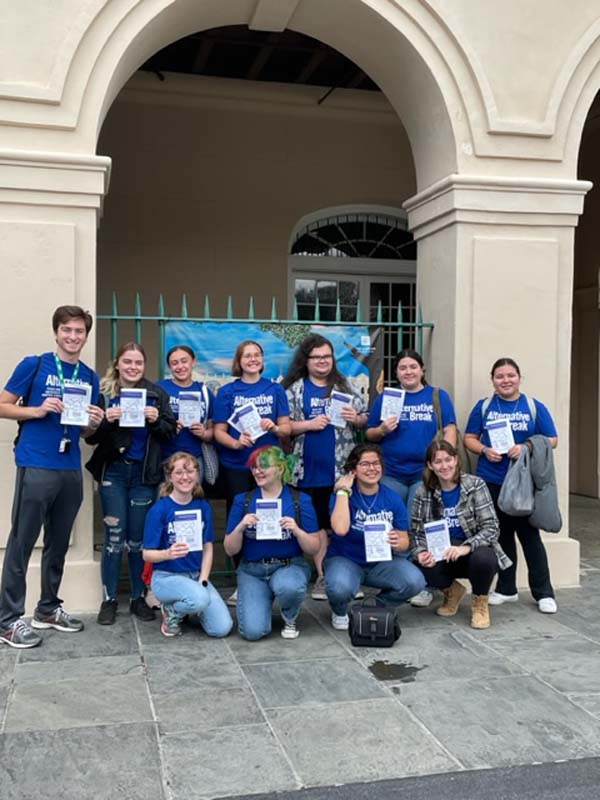 group of students in front of arch