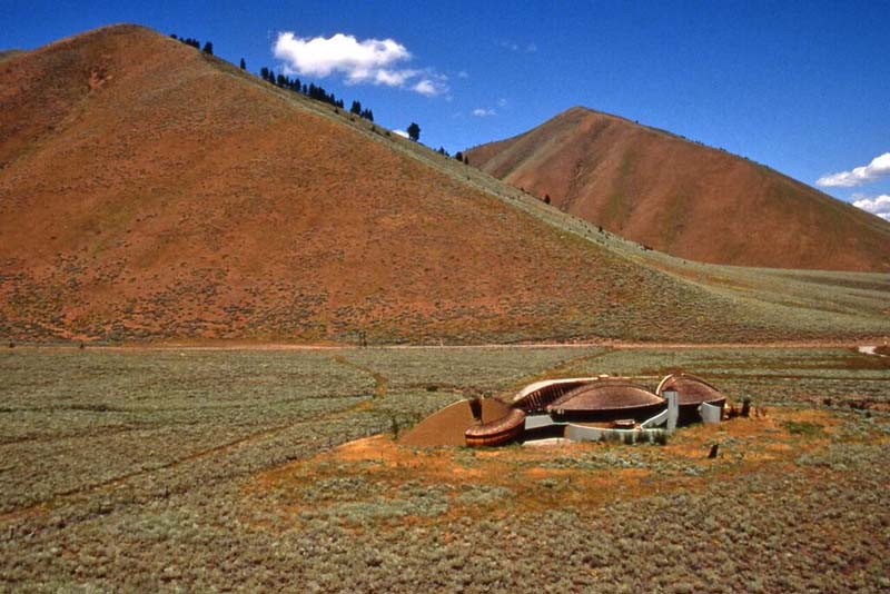 house of curved shapes and domes in foreground with foothills in background