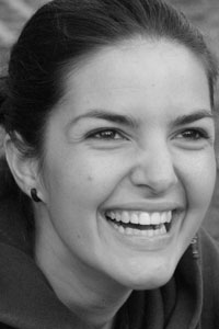 close-up black and white photo of Elisa Dainese, a woman with dark hair, smiling