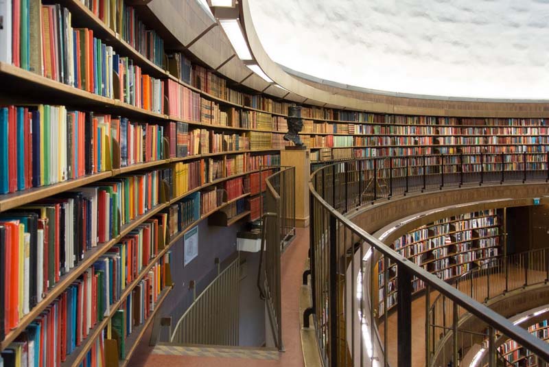 Floor-to-ceiling bookshelves line a series of curving concourses open to the floors below
