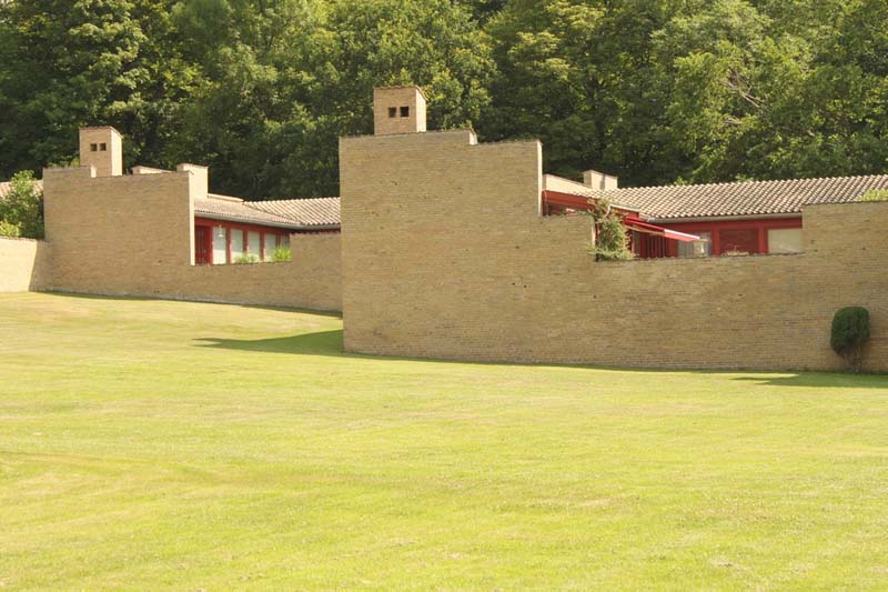 Unadorned masonry walls with varying heights provide privacy and enclose outdoor living spaces