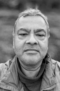 Arijit Sen, a man with short hair, looks directly at the camera and wears a winter jacket over a turtleneck