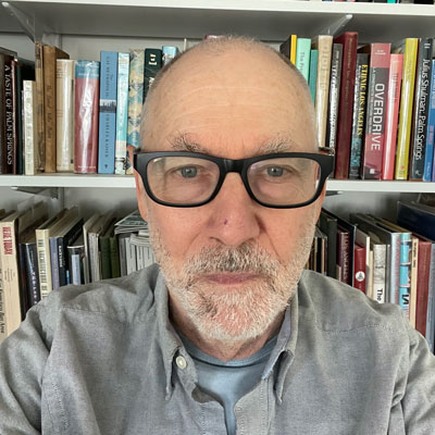 Robert Bruegmann, a white man with black glasses, in front of a bookshelf