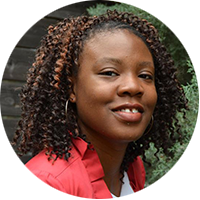 Tara Dudley is an African American woman wearing a salmon-colored blouse and smiling