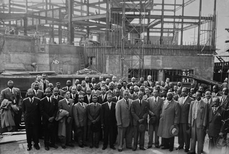 large group of men in front of a construction site