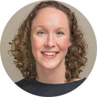 white woman with curly brown hair and gray shirt