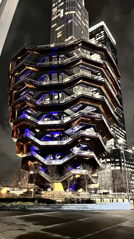 modern highrise with balconies lit up at night