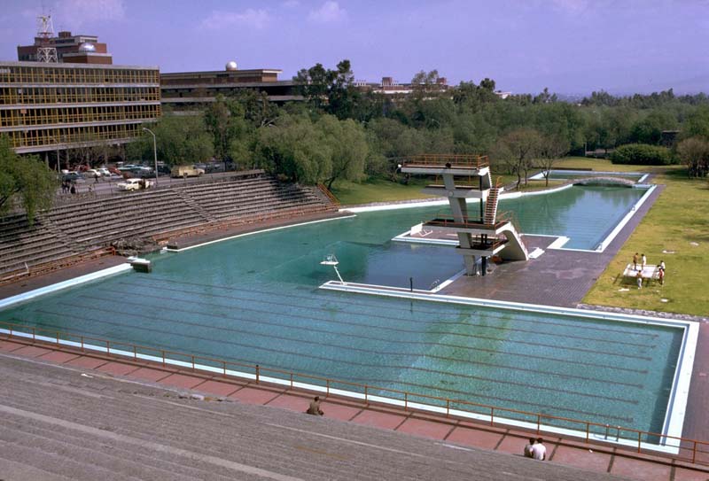 large pool with diving board and tiered seating