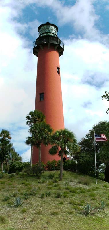 red lighthouse with palm trees in foreground